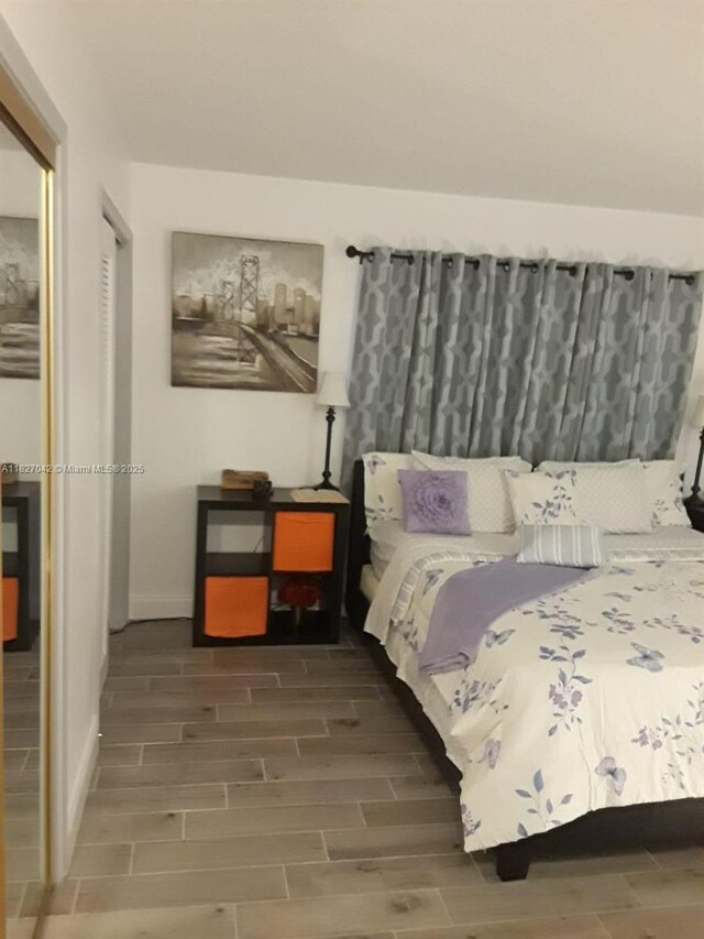 900 NE 12th Ave Unit 302, Hallandale Beach, FL 33009 - bedroom featuring wood tiled floors and baseboards