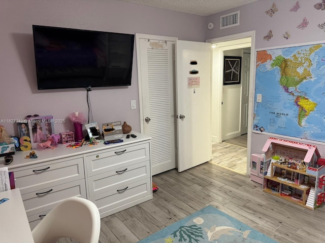 900 NE 12th Ave Unit 302, Hallandale Beach, FL 33009 - bedroom with light wood-style floors and a textured ceiling