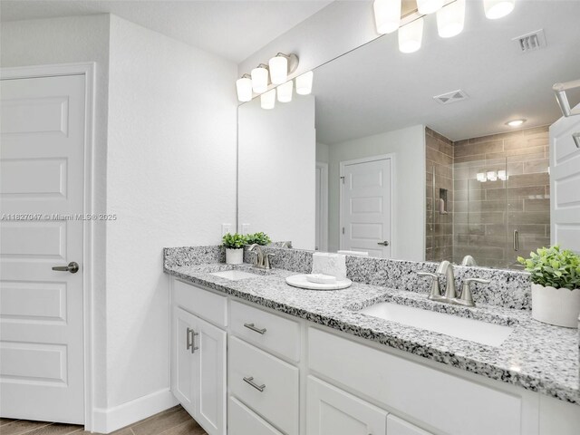 2405 Nelson Rd, Cape Coral, FL 33993 - bathroom with double vanity, a stall shower, and wood finished floors