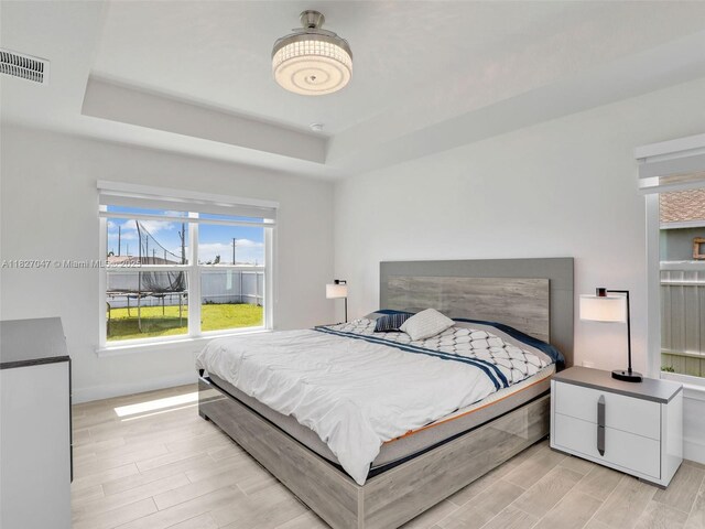 2405 Nelson Rd, Cape Coral, FL 33993 - bedroom featuring a raised ceiling and light wood-style flooring