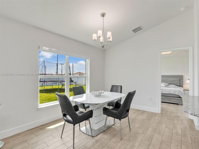 2405 Nelson Rd, Cape Coral, FL 33993 - dining room featuring a chandelier, light wood finished floors, and lofted ceiling