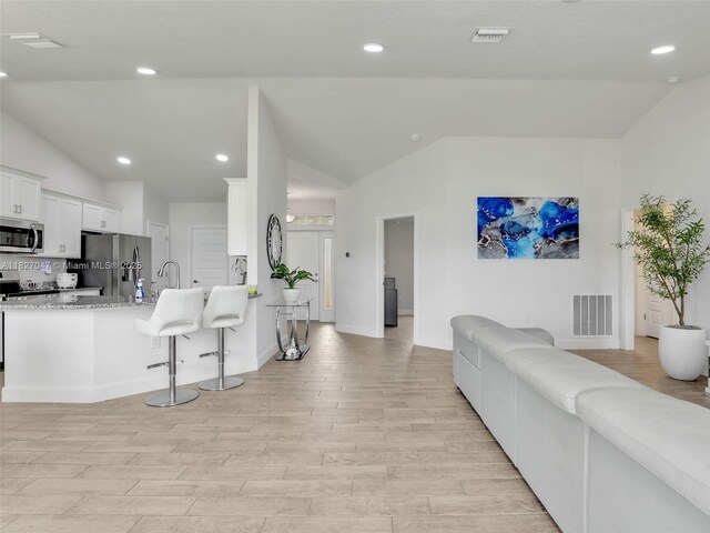 2405 Nelson Rd, Cape Coral, FL 33993 - living area with vaulted ceiling, light wood-type flooring, and recessed lighting