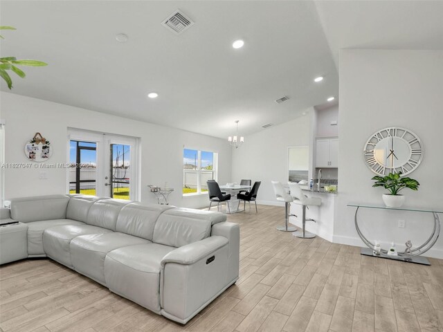 2405 Nelson Rd, Cape Coral, FL 33993 - living room featuring light wood-type flooring, a chandelier, lofted ceiling, and recessed lighting