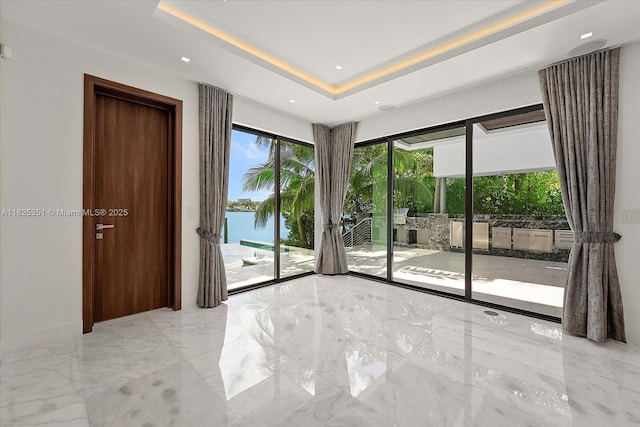 1311 Stillwater Dr, Miami Beach, FL 33141 - spare room featuring light marble finish flooring, a water view, a tray ceiling, and recessed lighting