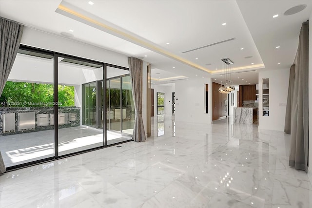 1311 Stillwater Dr, Miami Beach, FL 33141 - empty room with a tray ceiling, light marble finish floors, a chandelier, and recessed lighting