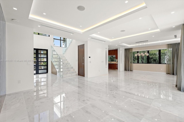 1311 Stillwater Dr, Miami Beach, FL 33141 - empty room featuring a raised ceiling, stairs, and plenty of natural light