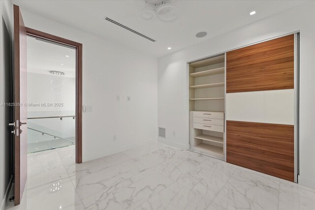 1311 Stillwater Dr, Miami Beach, FL 33141 - unfurnished bedroom with light marble finish floors and recessed lighting