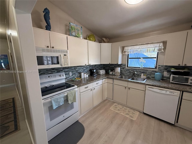211 Banyan Ln, Tavernier, FL 33070 - kitchen featuring white appliances, decorative backsplash, light wood-style floors, white cabinets, and lofted ceiling