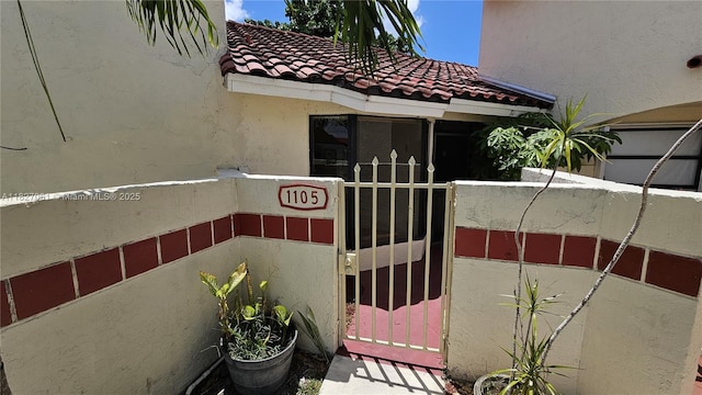1105 San Remo Cir, Homestead, FL 33035 - property entrance featuring a tiled roof, stucco siding, and a gate