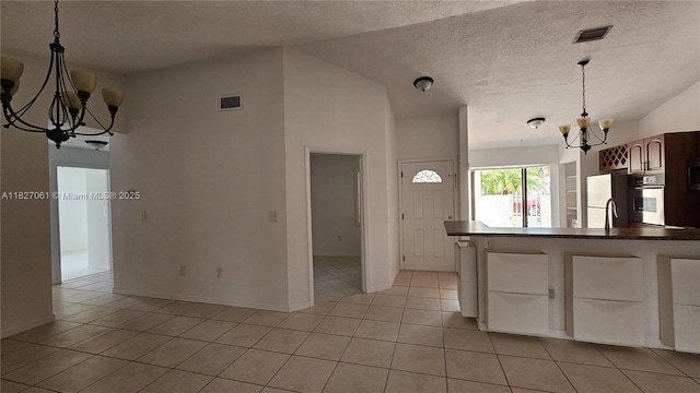 1105 San Remo Cir, Homestead, FL 33035 - kitchen with a chandelier, light tile patterned flooring, decorative light fixtures, dark countertops, and a textured ceiling