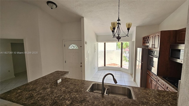 1105 San Remo Cir, Homestead, FL 33035 - kitchen featuring stainless steel appliances, light tile patterned floors, a chandelier, decorative light fixtures, and dark stone countertops