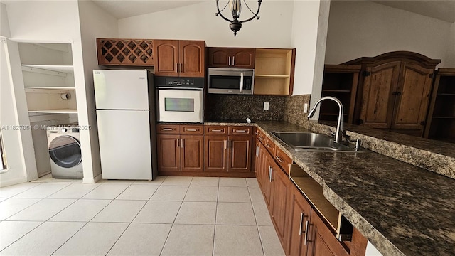 1105 San Remo Cir, Homestead, FL 33035 - kitchen featuring white appliances, washer / dryer, open shelves, vaulted ceiling, and decorative backsplash