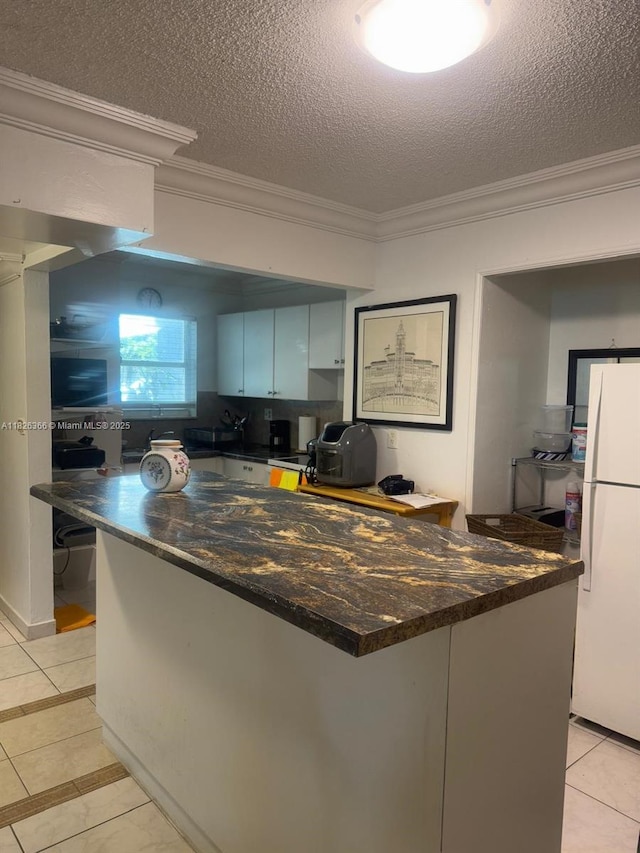 8821 W Flagler St Unit 108, Miami, FL 33174 - kitchen featuring freestanding refrigerator, crown molding, a textured ceiling, and light tile patterned flooring