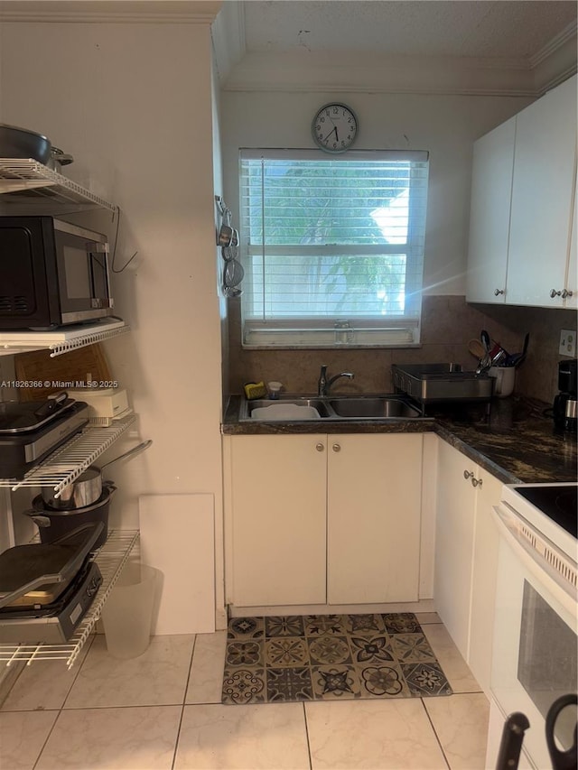 8821 W Flagler St Unit 108, Miami, FL 33174 - kitchen featuring crown molding, white cabinets, electric range, dark countertops, and decorative backsplash