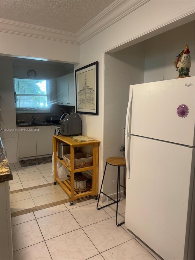 8821 W Flagler St Unit 108, Miami, FL 33174 - kitchen with freestanding refrigerator, ornamental molding, dark countertops, and a textured ceiling