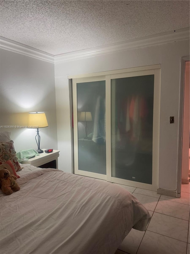 8821 W Flagler St Unit 108, Miami, FL 33174 - bedroom featuring crown molding, a closet, a textured ceiling, and light tile patterned floors