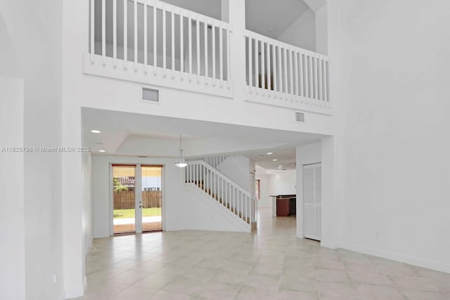 32157 SW 207th Ave, Homestead, FL 33030 - unfurnished living room featuring a towering ceiling, stairs, recessed lighting, and tile patterned floors