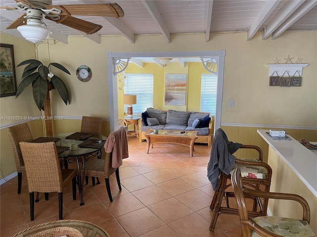 185 Gardenia St, Tavernier, FL 33070 - dining space featuring wainscoting, beam ceiling, light tile patterned floors, ceiling fan, and wood walls