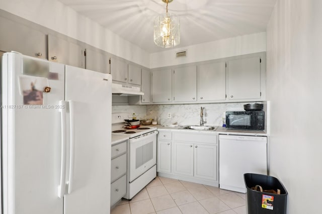 13450 SW 3rd St Unit 408D, Pembroke Pines, FL 33027 - kitchen with white appliances, under cabinet range hood, light countertops, light tile patterned floors, and decorative light fixtures