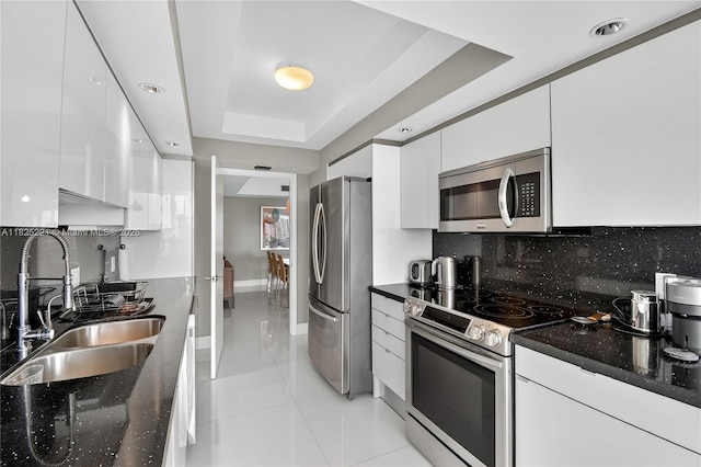 7000 Island Blvd Unit 1408, Aventura, FL 33160 - kitchen with appliances with stainless steel finishes, modern cabinets, white cabinetry, a raised ceiling, and backsplash