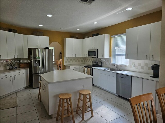 21300 Waycross Dr, Boca Raton, FL 33428 - kitchen with stainless steel appliances, a kitchen island, tasteful backsplash, a breakfast bar, and light countertops