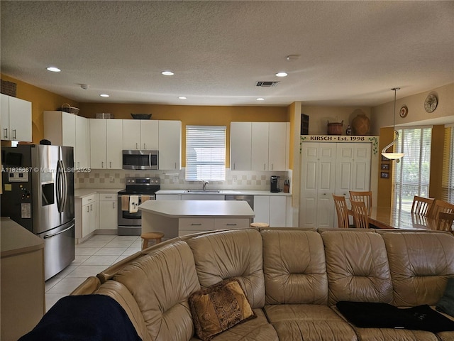 21300 Waycross Dr, Boca Raton, FL 33428 - kitchen with stainless steel appliances, open floor plan, decorative backsplash, light countertops, and a textured ceiling