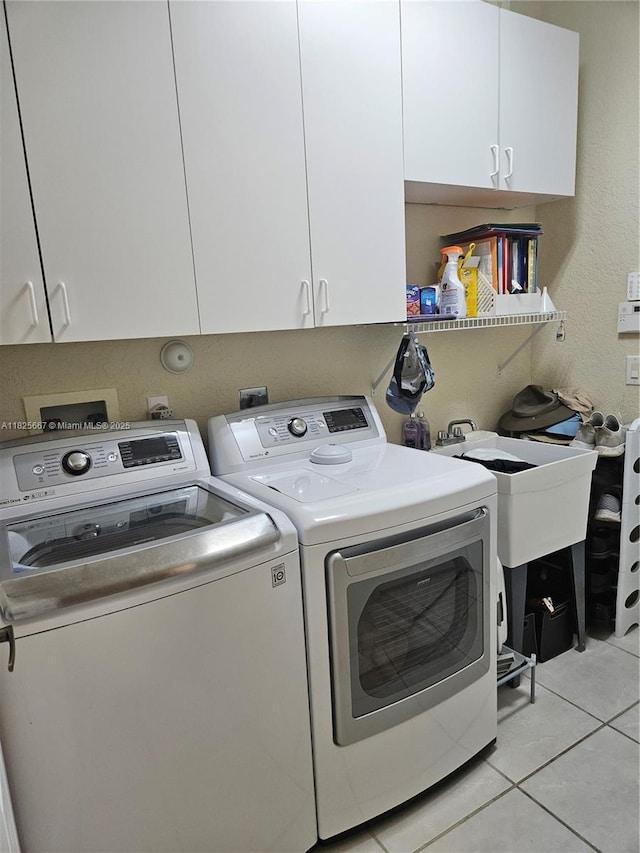 21300 Waycross Dr, Boca Raton, FL 33428 - washroom with washer and clothes dryer, cabinet space, and light tile patterned flooring
