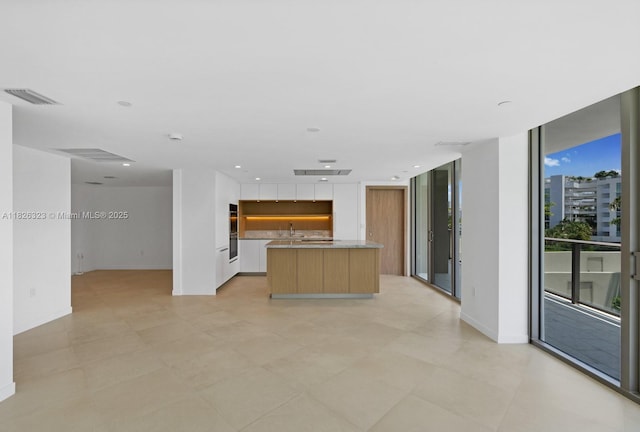 1135 103rd St Unit 408, Bay Harbor Islands, FL 33154 - kitchen with modern cabinets, a kitchen island with sink, open floor plan, light countertops, and floor to ceiling windows
