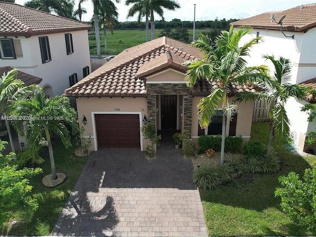 134 NE 23rd Ter, Homestead, FL 33033 - mediterranean / spanish house with a tiled roof, stucco siding, an attached garage, and decorative driveway