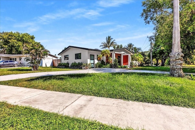 5890 SW 13th St, Plantation, FL 33317 - ranch-style house with a front yard, stucco siding, and driveway