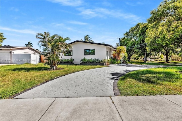 5890 SW 13th St, Plantation, FL 33317 - view of front of property with curved driveway, stucco siding, and a front yard
