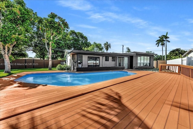 5890 SW 13th St, Plantation, FL 33317 - view of swimming pool featuring a wooden deck and a fenced backyard