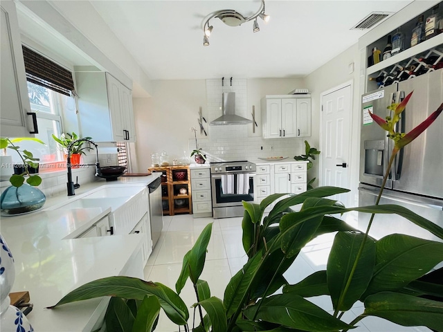 759 NE 87th St, Miami, FL 33138 - kitchen with stainless steel appliances, wall chimney exhaust hood, decorative backsplash, light tile patterned flooring, and light countertops