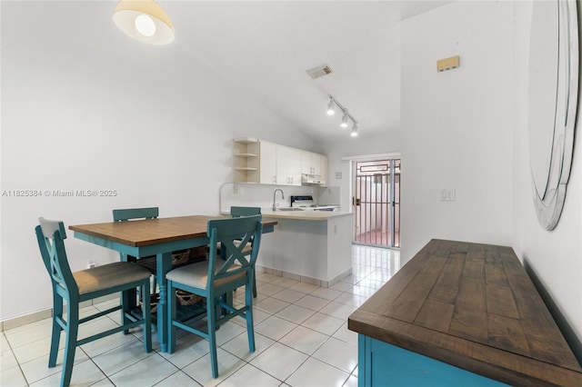 7101 W 24th Ave Unit 27, Hialeah, FL 33016 - dining area with vaulted ceiling, light tile patterned flooring, and track lighting