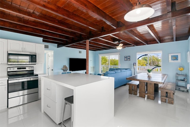 66 Seagate Blvd, Key Largo, FL 33037 - kitchen featuring appliances with stainless steel finishes, a wood ceiling with exposed beams, white cabinetry, light countertops, and a ceiling fan