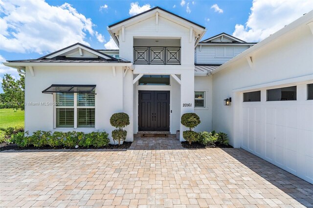 20161 SE Bridgewater Dr, Jupiter, FL 33458 - doorway to property featuring stucco siding, a standing seam roof, a garage, and a metal roof