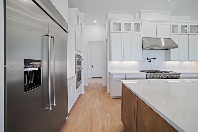 20161 SE Bridgewater Dr, Jupiter, FL 33458 - kitchen with appliances with stainless steel finishes, exhaust hood, light countertops, white cabinetry, and recessed lighting