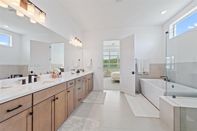 20161 SE Bridgewater Dr, Jupiter, FL 33458 - ensuite bathroom with a freestanding tub, plenty of natural light, double vanity, tile patterned floors, and recessed lighting