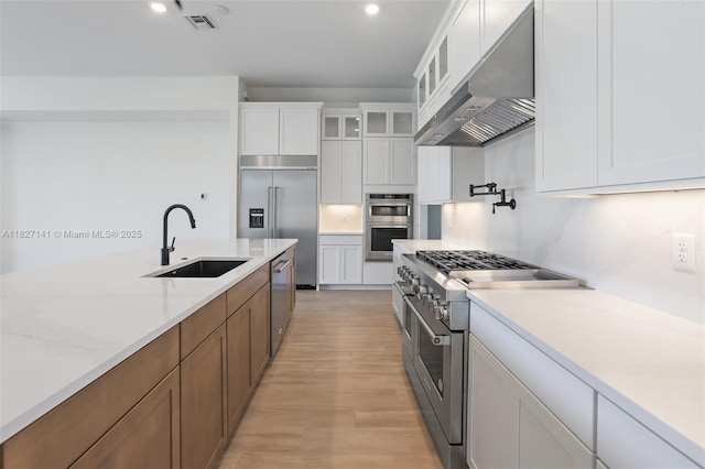 20161 SE Bridgewater Dr, Jupiter, FL 33458 - kitchen featuring under cabinet range hood, premium appliances, light wood finished floors, white cabinets, and recessed lighting