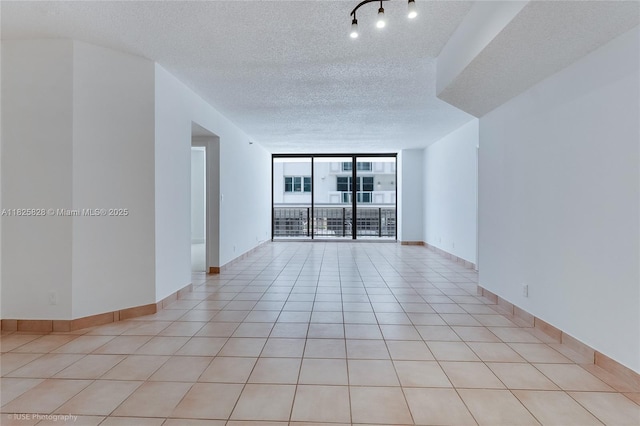 9455 Collins Ave Unit 301, Surfside, FL 33154 - spare room featuring a textured ceiling, expansive windows, and light tile patterned flooring