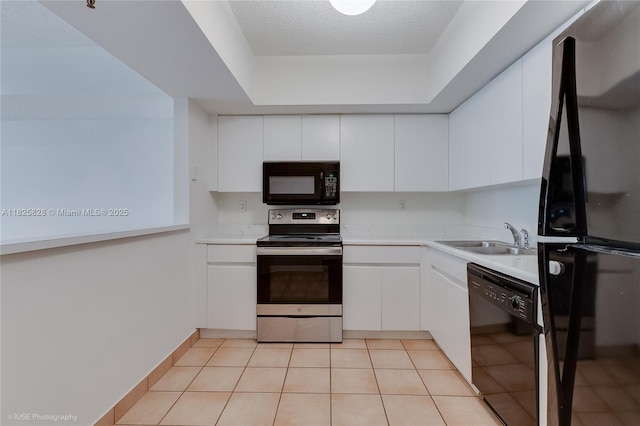 9455 Collins Ave Unit 301, Surfside, FL 33154 - kitchen featuring black appliances, white cabinets, light countertops, a textured ceiling, and light tile patterned floors