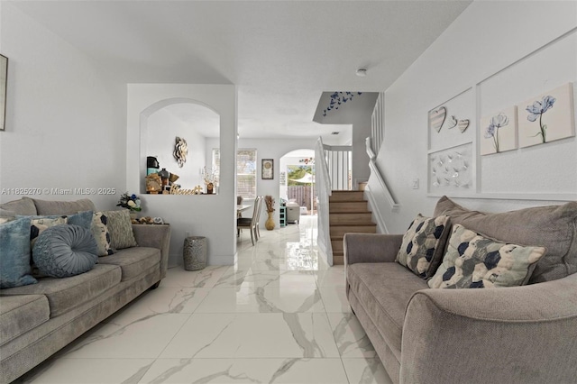 3818 SW 171st Ter, Miramar, FL 33027 - living room featuring arched walkways, light marble finish flooring, and stairway