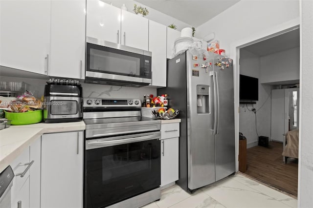 3818 SW 171st Ter, Miramar, FL 33027 - kitchen featuring appliances with stainless steel finishes, white cabinetry, light marble finish flooring, and light countertops