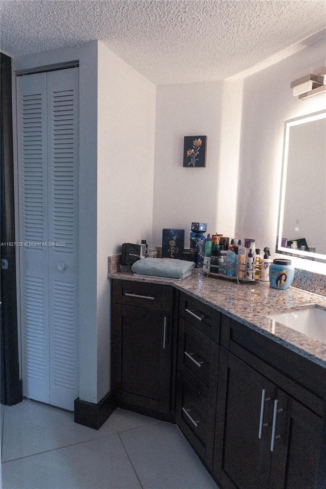 8215 SW 152nd Ave Unit G-307, Miami, FL 33193 - bathroom featuring a closet, double vanity, a textured ceiling, and tile patterned flooring