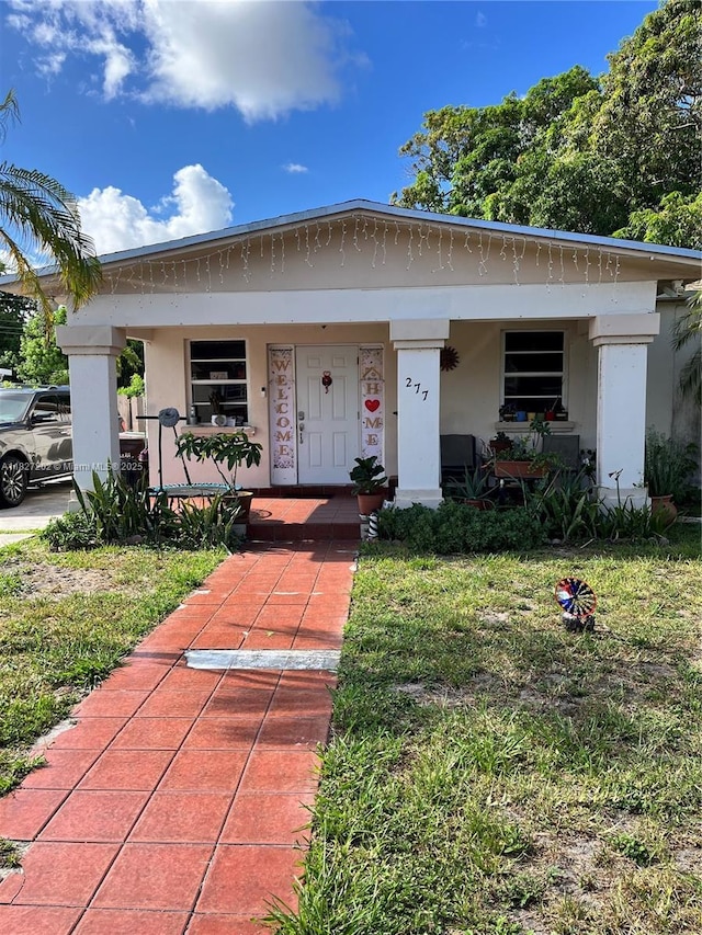 277 E 63rd St, Hialeah, FL 33013 - bungalow-style house featuring covered porch, stucco siding, and a front yard