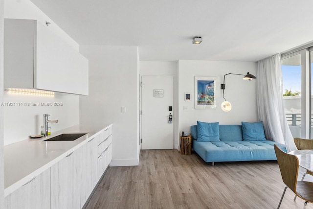 6080 Collins Ave Unit 302, Miami Beach, FL 33140 - kitchen with modern cabinets, light wood finished floors, light countertops, and white cabinetry