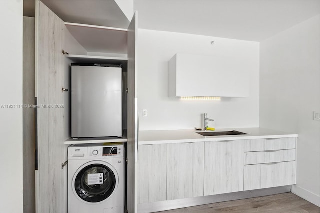6080 Collins Ave Unit 302, Miami Beach, FL 33140 - washroom with stacked washing machine and dryer and wood finished floors