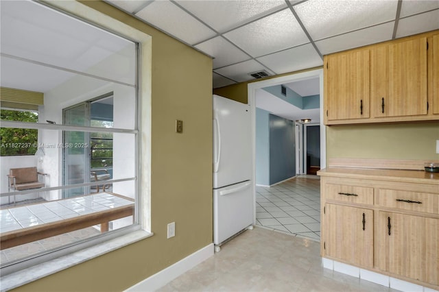 4168 Inverrary Dr Unit 402, Lauderhill, FL 33319 - kitchen with freestanding refrigerator, light countertops, light brown cabinets, light tile patterned flooring, and a drop ceiling