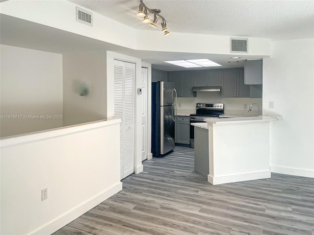 2009 SE 10th Ave Unit 318, Fort Lauderdale, FL 33316 - kitchen with freestanding refrigerator, electric stove, light countertops, wood finished floors, and under cabinet range hood