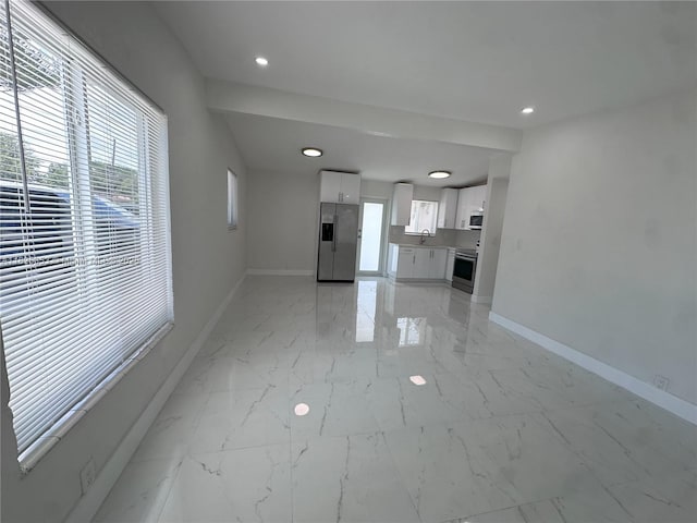 3231 NW 48th Ter, Miami, FL 33142 - unfurnished living room featuring healthy amount of natural light, light marble finish floors, and recessed lighting